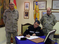 El general Muro firma en el libro de honor de la Brigada de Sanidad en presencia de su jefe, general Rey