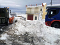 Una máquina quitanieves trabajando para retirar la nieve y abre paso a un camión que se encuentra atrapado.