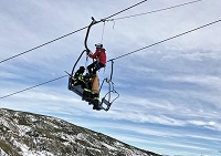 Imagen del simulacro de rescate de esquiadores en el telesilla de la Estación Invernal y de Montaña de Leitariegos. Los esquiadores atrapados fueron bajados mediante el empleo de la polea de rescate.