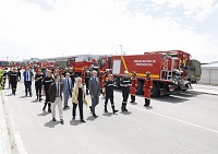 La comitiva pasa por delande del despliegue de vehiculos de lucha contra incendios forestales