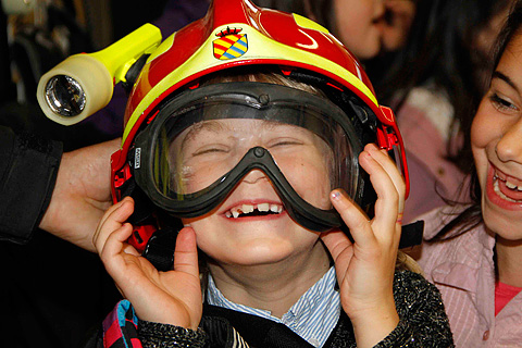 Uno de los ni&ntilde;os, con el casco de intervenci&oacute;n de la UME, bromea con sus compa&ntilde;eros.