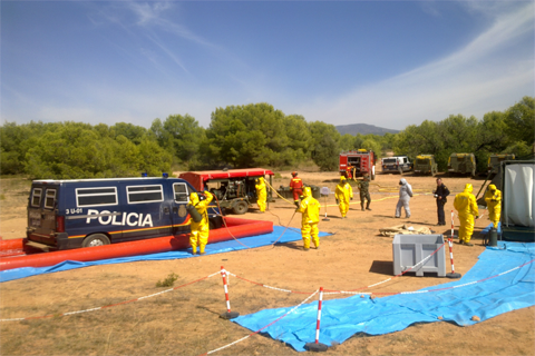 Efectivos de la UME descontaminando un veh&iacute;culo del CNP durante el ejercicio.