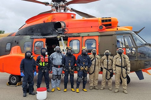 Tripulaci&oacute;n del helic&oacute;ptero, rescatadores y equipo control y descontaminaci&oacute;n equipados con trajes y m&aacute;scaras de protecci&oacute;n qu&iacute;mica