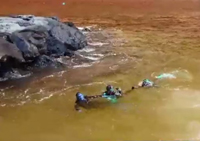 El soldado Dominguez arrastrando a uno de los submarinistas hasta tierra firme